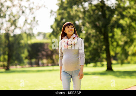 happy pregnant asian woman walking at park Stock Photo