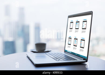 laptop with smartphone interface design on screen Stock Photo