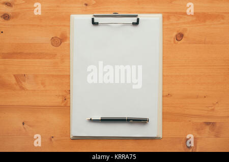 Overhead view of blank clipboard note pad paper with pen on office table as mock up copy space for check or to do list Stock Photo