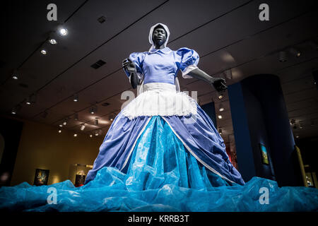WASHINGTON, DC - A mixed media piece by South African artist Mary Sibande titled Sophie-Merica (2009). It combines the traditional blue uniform of domestic workers with a Cinderella-like gown that suggests indomitable imagination. It is on display at the Smithsonian National Museum of African Art in Washington DC. Located on the National Mall in Washington DC, the National Museum of African Art is the only national museum in the United States dedicated to the collection, exhibition, conservation, and study of the arts of Africa. Stock Photo