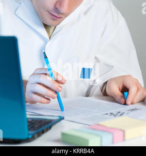 Young scientist reads an interesting research publication Stock Photo