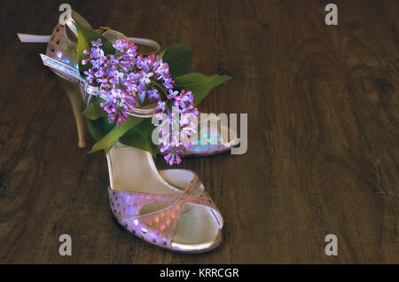 Argentine tango stilettos and lilac flower on dark wooden floor, text space Stock Photo