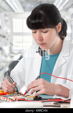 Tech repairs electronic device in modern laboratory Stock Photo
