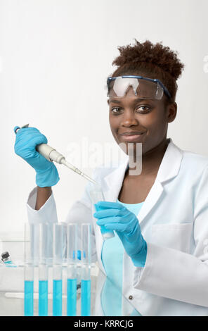 African-american scientist or graduate student in lab coat and protective wear works with liquid sample Stock Photo