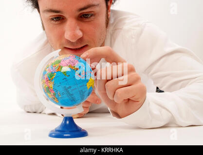 Junger Mann mit Miniatur-Globus - man with globe Stock Photo