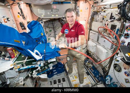 NASA International Space Station Expedition 53 prime crew member Italian astronaut Paolo Nespoli of the European Space Agency fills a personal radiation shielding garment with water November 7, 2017 in Earth orbit. Stock Photo