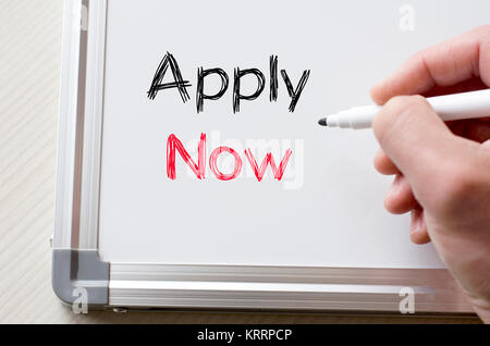 Apply now written on whiteboard Stock Photo