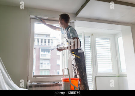 Plasterer renovating indoor walls and ceilings. Stock Photo