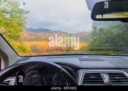 rain drops on the window of the car. autumnal rainy landscape blurred Stock Photo