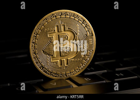 Gold Bitcoin coin on keyboard Stock Photo