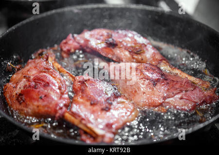 Goose drumstick frying in a pan Stock Photo