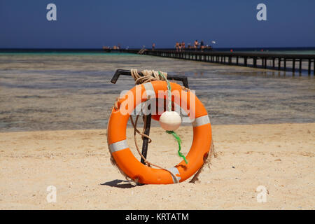 Lifebuoy on sandy beach, near coral reef. Marsa Alam, Egypt Stock Photo