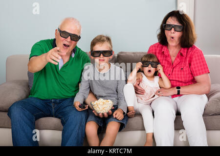 Grandparent And Grandchildren Watching 3D Movie Stock Photo