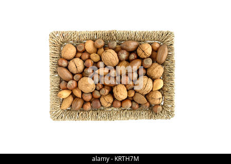 Whole Walnuts, pecan nuts, hazelnuts and almonds with shell in a brown wicker basket on white background. Top View. Stock Photo