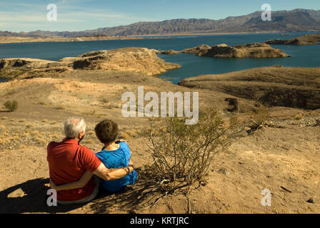 Couple sits on beach at Lake Mead National Recreation Area Nevada, USA. Stock Photo