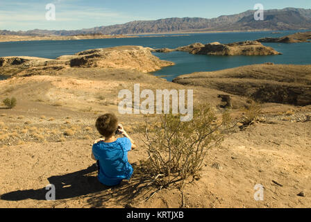 Woman talks on cellphone at Lake Mead National Recreation Area Nevada, USA. Stock Photo