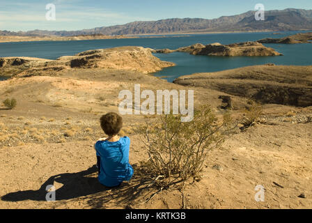 Woman sits on beach at Lake Mead National Recreation Area Nevada, USA. Stock Photo