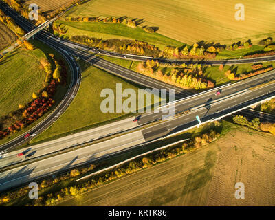 Aerial view of a highway amid fields with cars on it Stock Photo