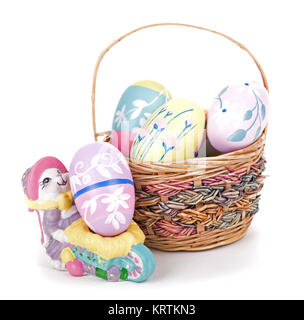 Basket of colorful Easter eggs and bunny figurine on a white background Stock Photo