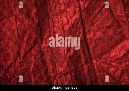 Close-up of woven polypropylene groundsheet lit with red light. Stock Photo
