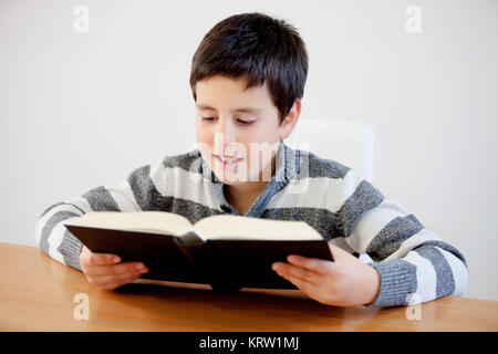 Concentrated teenage boy of thirteen reading a book Stock Photo