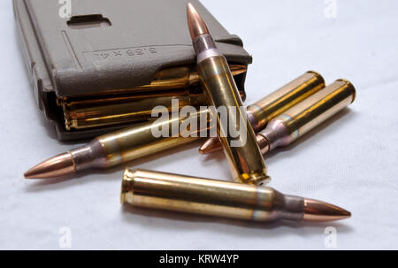 Several .223 caliber rounds and a loaded magazine on a white background Stock Photo