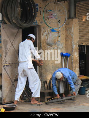 People work at bicycle shop in Hazrat Nizamuddin complex Islamic area New Delhi India Stock Photo