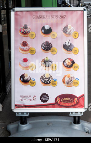 A sign outside Gombo's Heimishe Bakery in Crown Heights, Brooklyn advertising varieties of donuts, a traditional Chanukkah dish. Stock Photo