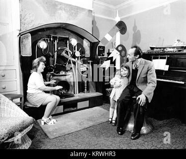 Man woman and child sitting in front of strange machine, England, Great Britain Stock Photo