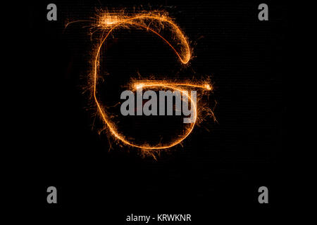 Letter G made of sparklers on black Stock Photo