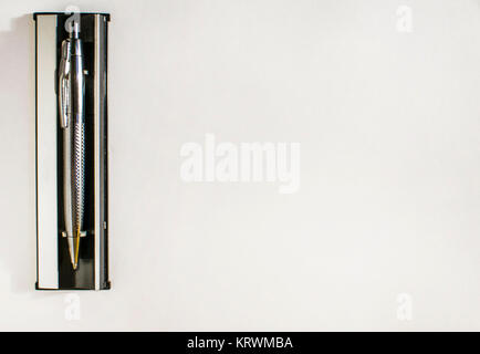 silver pen with stand lies on white paper Stock Photo