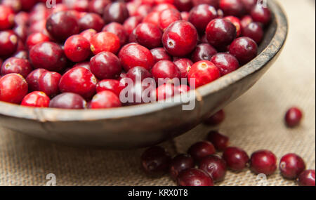 Fresh cranberries in rustic wooden bowl on burlap Background an Stock Photo