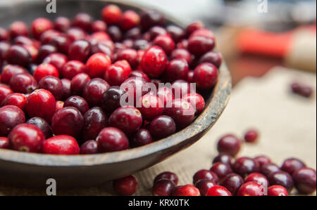 Fresh cranberries in rustic wooden bowl on burlap Background an Stock Photo