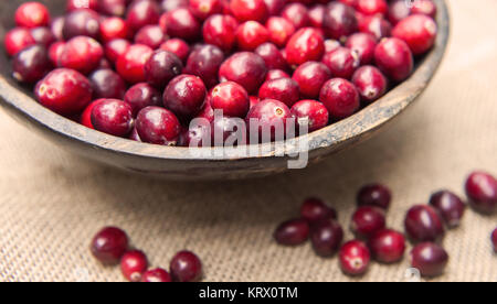 Fresh cranberries in rustic wooden bowl on burlap Background an Stock Photo