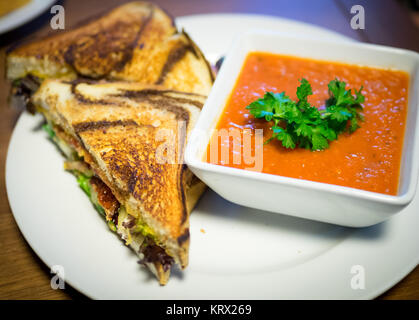 A BLT sandwich (bacon, lettuce, tomato sandwich) on marble rye bread and tomato soup from Culina Cafe in Edmonton, Alberta, Canada. Stock Photo