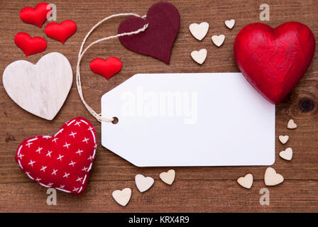 Label With Copy Space For Advertisement. Red Textile Hearts On Wooden Gray Background. Retro Or Vintage Style. Stock Photo