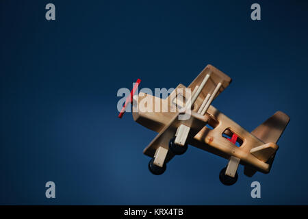 Wooden plane flying at dusk -  Side view Stock Photo