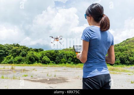 Woman controlling the flying drone Stock Photo