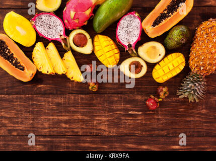 Tropical fruit on dark wooden background, top view Stock Photo