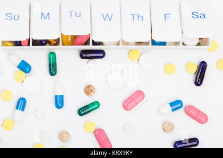 Color pills capsules and weekly pill organizer Stock Photo