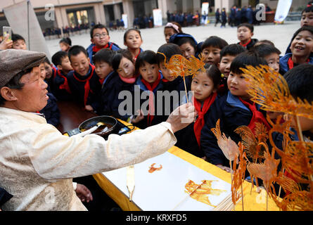 Hefei, China's Anhui Province. 21st Dec, 2017. Children watch the works of sugar arts at a primary school in Hefei, east China's Anhui Province, Dec. 21, 2017. The school invited local inheritors of intangible culture heritages, helping students learn more about traditional folk arts. Credit: Liu Junxi/Xinhua/Alamy Live News Stock Photo