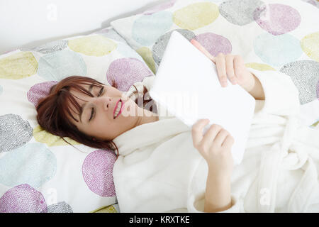 beautiful girl reads a book in her bed Stock Photo