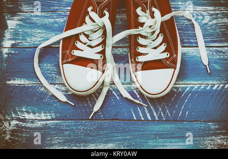 pair of red sneakers on a blue shabby wooden surface Stock Photo