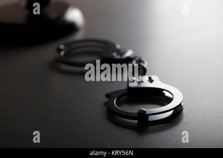 Criminal law concept. Cuffs and jugde gavel on stone background. Stock Photo