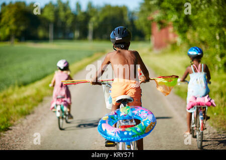 Children cycling on a rural road in Gullspang, Sweden