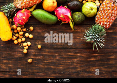 Tropical fruit on dark wooden background, top view Stock Photo