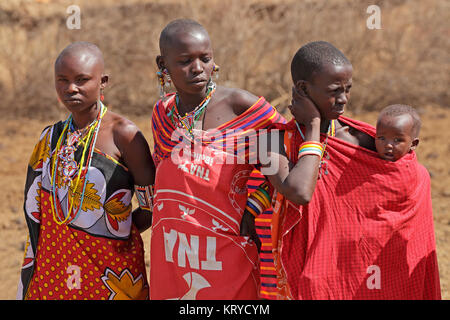 AMBOSELI, KENYA - AUGUST 31, 2013:Unidentified Masai women and child with traditional decorations and colorful red garments. Stock Photo