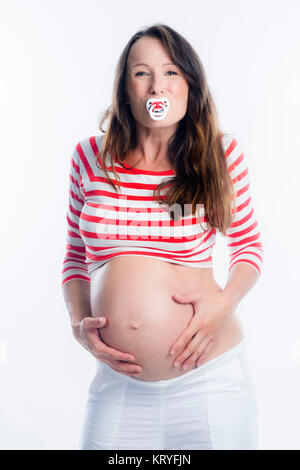 Schwangere Frau mit Schnuller im Mund - pregnant woman with dummy Stock Photo