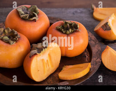 fresh persimmons on copper plate