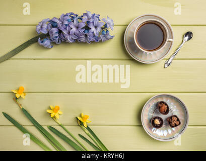 Cup of coffee,  and flowers on a wooden background. Flat lay. Stock Photo